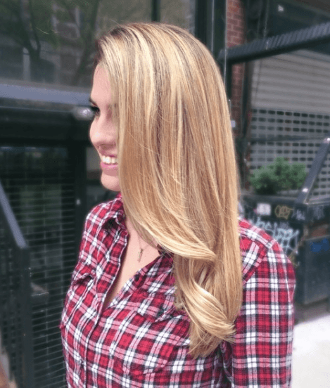 vue de côté d'une femme aux cheveux longs et usés d'une couleur blonde naturelle