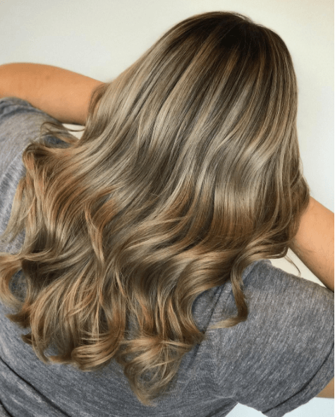 vue arrière d'une femme aux cheveux longs et aux différentes nuances de blond