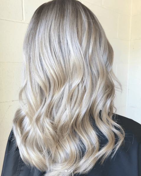Vue arrière des longs cheveux blonds d'une femme aux tons de blond perlé 