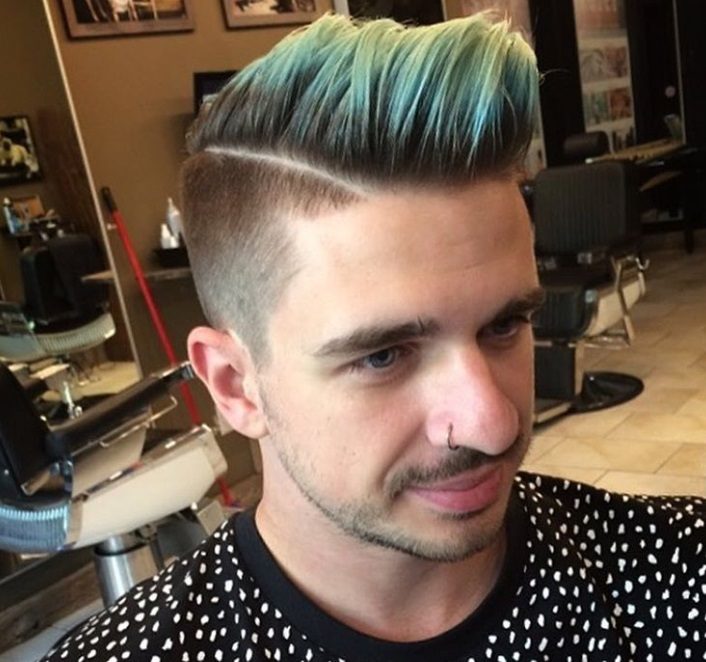 Plan rapproché d'un homme avec une coupe de cheveux colorée dans un salon de coiffure.