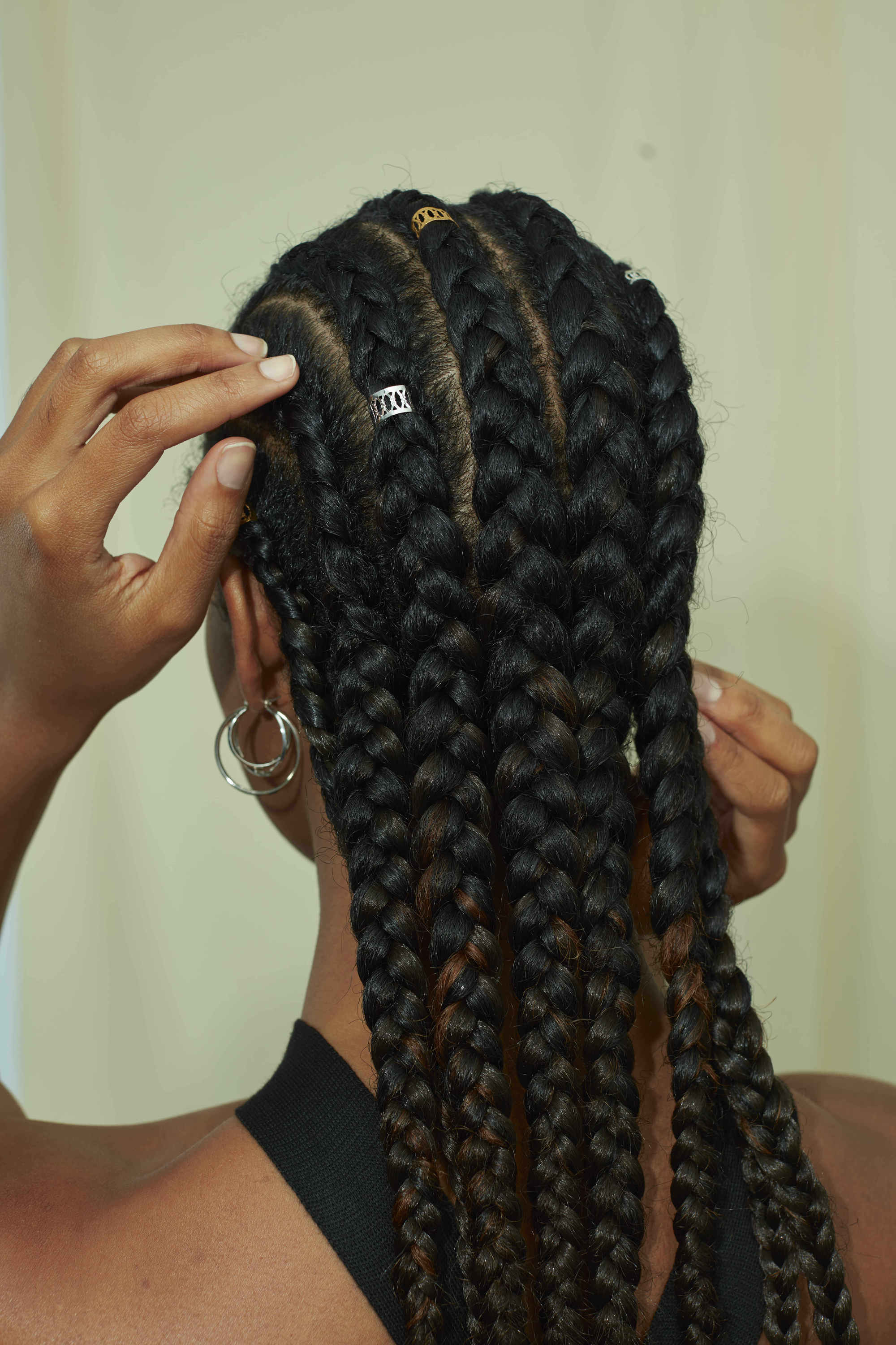 Femme avec ses cheveux de type 4a tressés en cornouillers