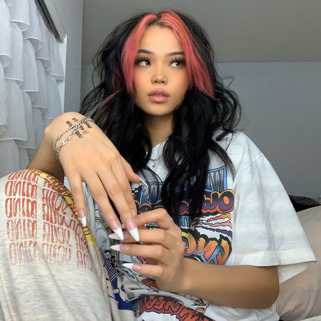 Fille aux longs cheveux bruns avec des mèches rouges sur le devant 