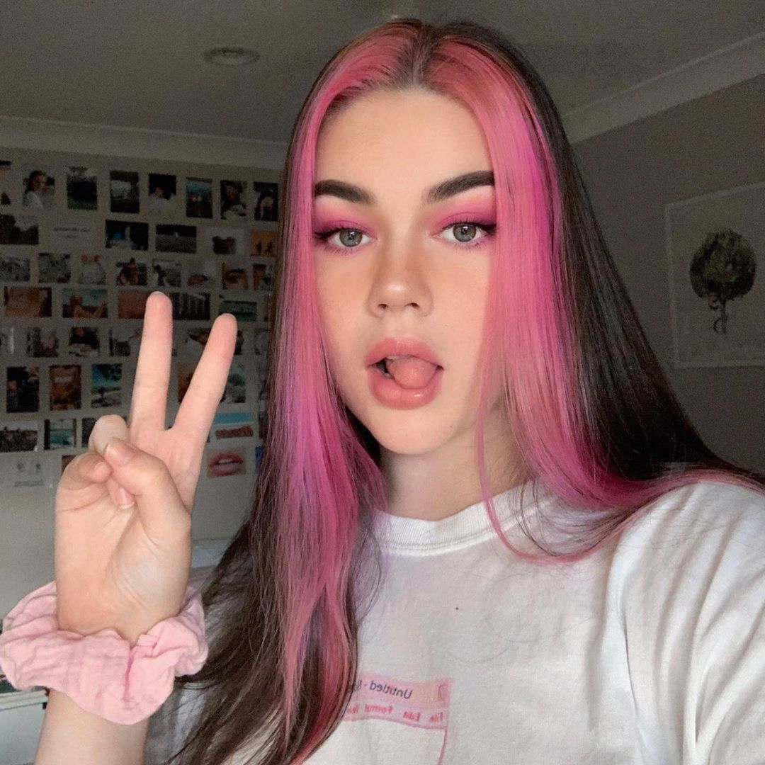 Fille aux cheveux brun foncé avec des mèches roses sur le devant