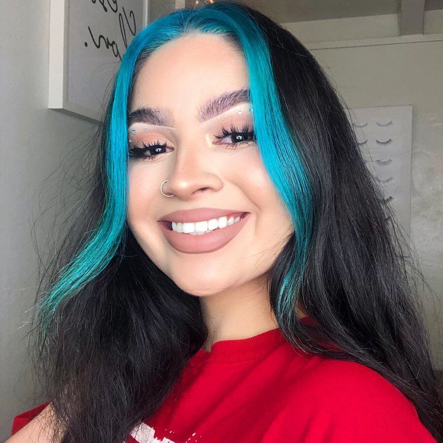 Femme aux cheveux longs brun foncé avec des mèches de cheveux bleus e fille