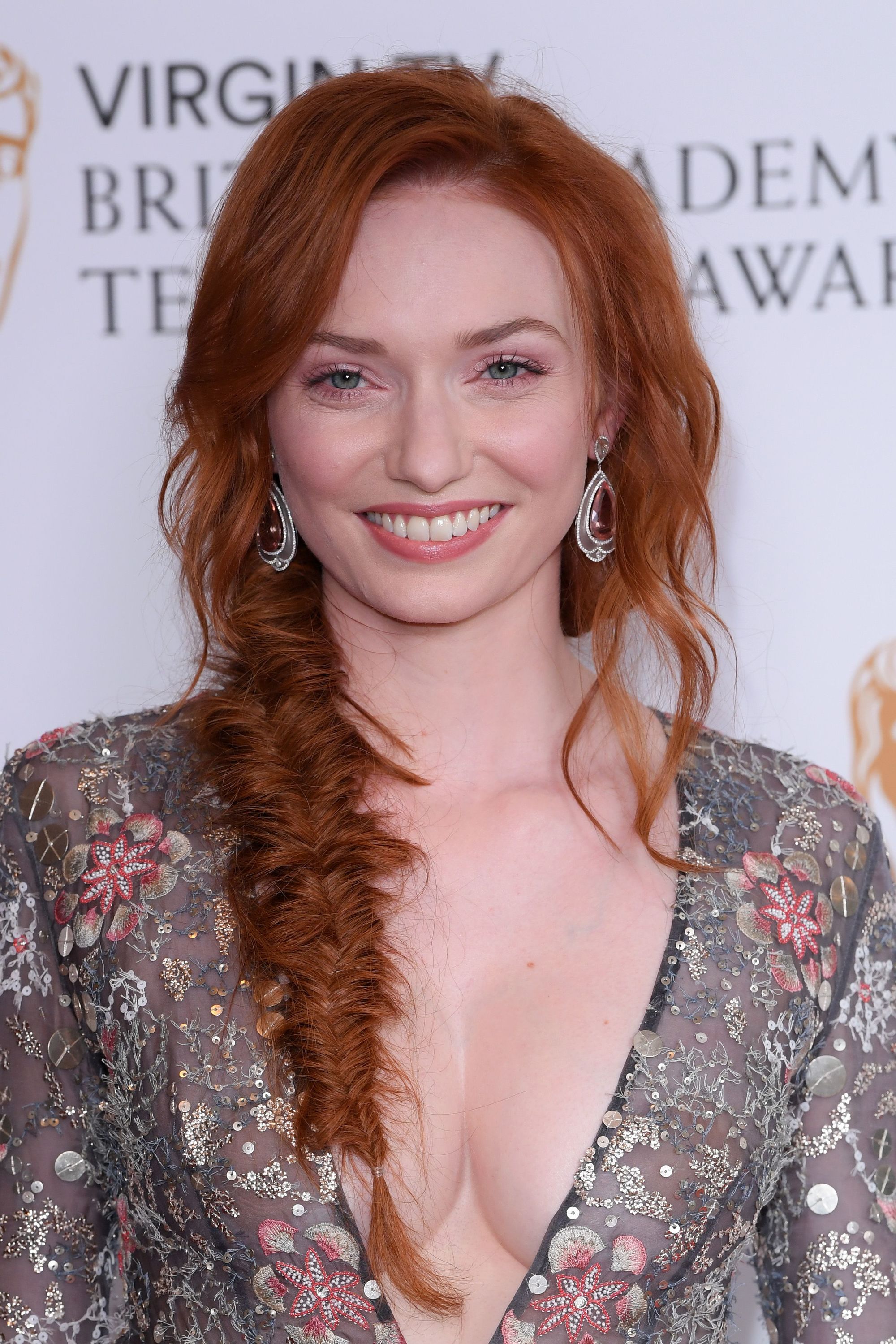 des tresses faciles pour les cheveux longs : eleanor tomlinson avec une tresse en queue de poisson sur le tapis rouge de la télévision vierge bafta awards, portant une robe à fleurs
