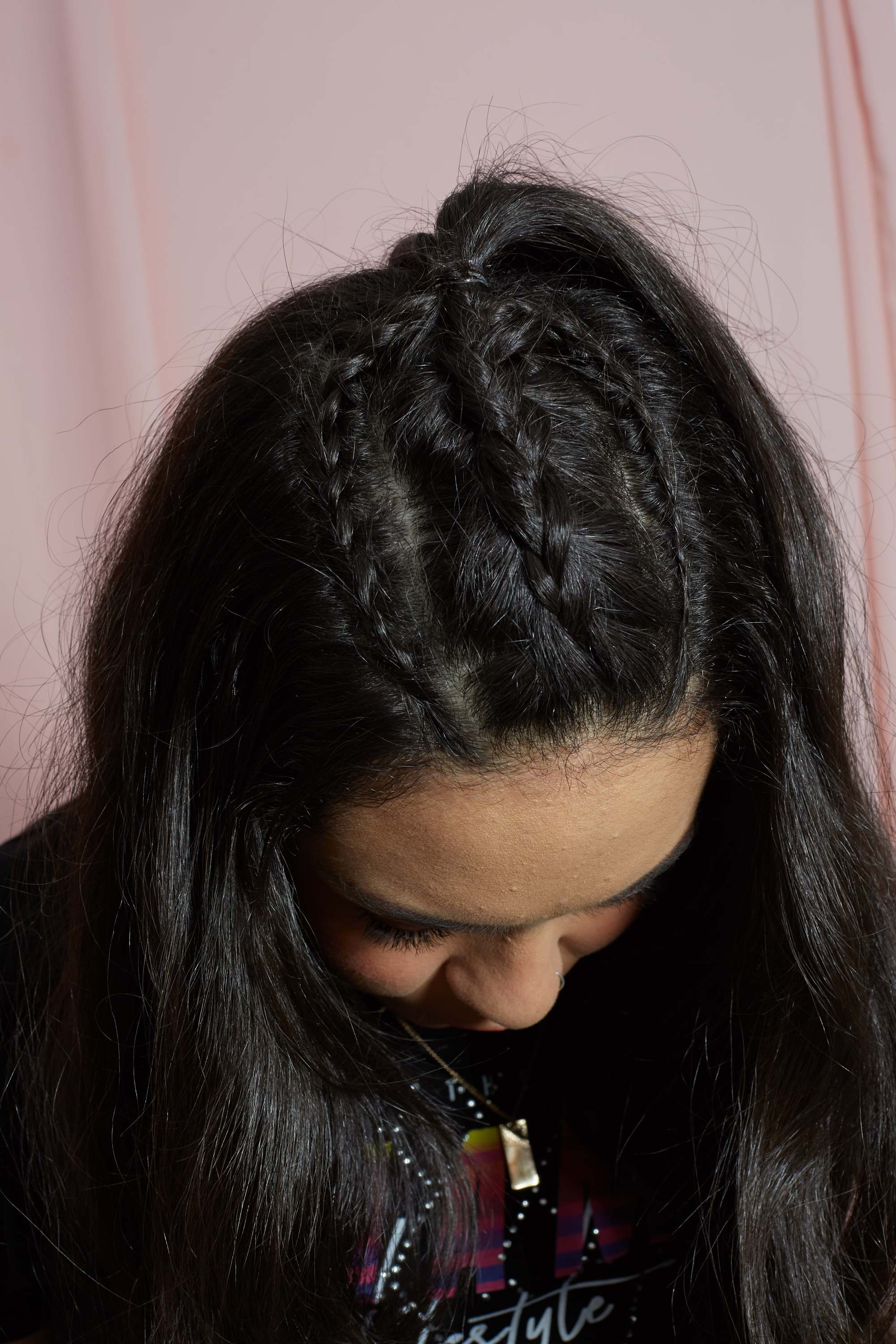 femme avec une tresse de licorne sur de longs cheveux ondulés brun foncé