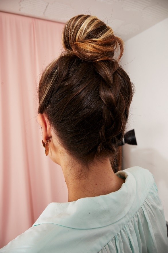Femme aux cheveux bruns surlignés, avec une tresse hollandaise à l'envers
