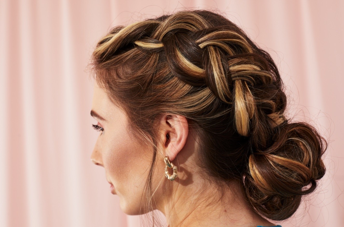 Femme aux mèches brunes dans un double chignon hollandais tressé