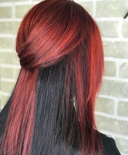vue de dos d'une femme aux cheveux raides moitié rouges et moitié noirs