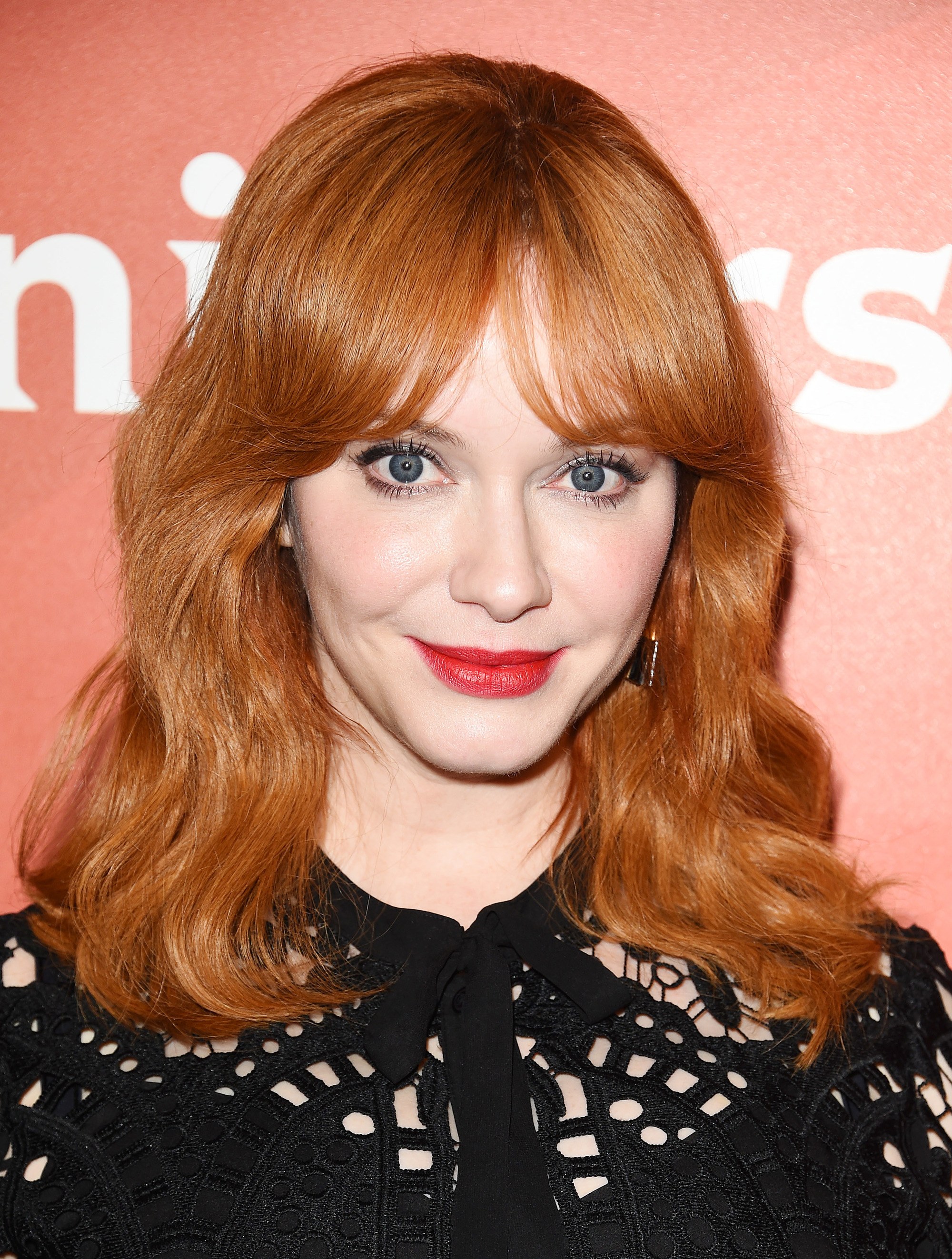 christina hendricks : cheveux roux ondulés de longueur moyenne et frange de bardot 