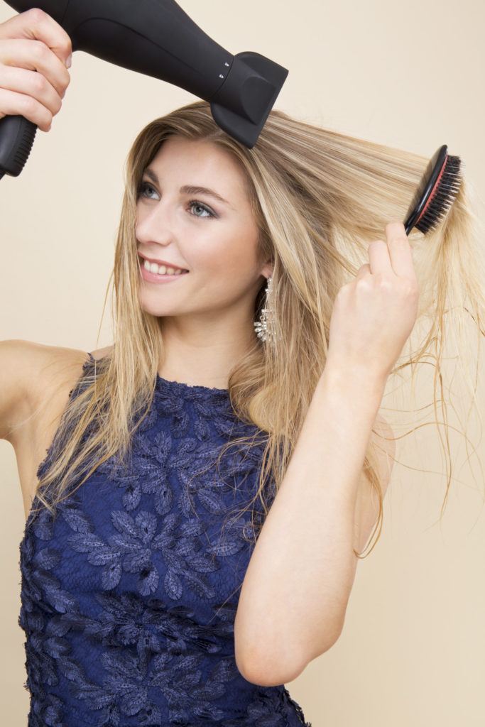 Comment friser les cheveux d'une blonde au fer plat à l'aide d'un sèche-cheveux et d'une brosse