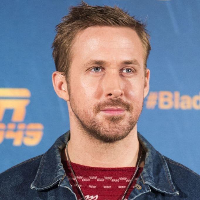 Coupe de cheveux de Ryan Gosling : Ryan Gosling avec une coupe de cheveux à pointes, portant un haut à motifs rouges et une veste en jean
