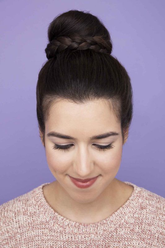 Femme aux cheveux bruns foncés dans un chignon tressé