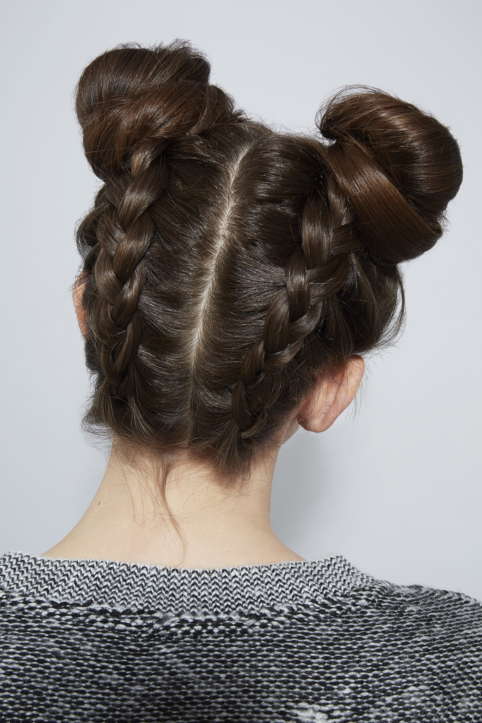 Femme brune avec des petits pains tressés à l'envers