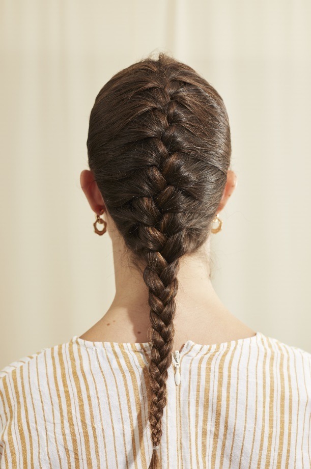 Femme aux longs cheveux bruns avec une tresse française