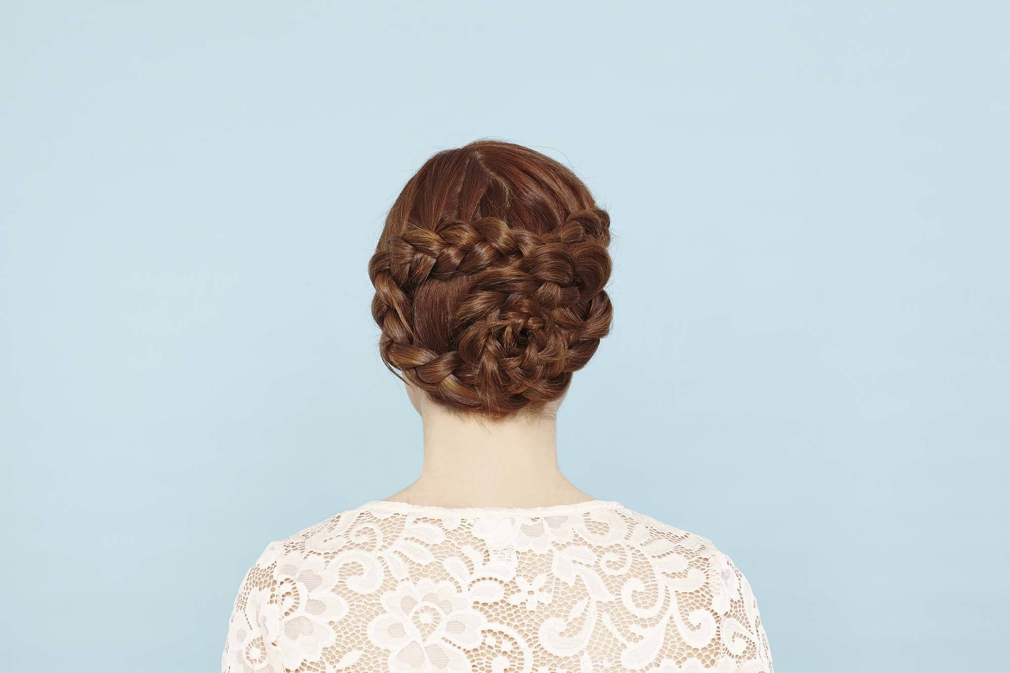 Femme aux cheveux roux dans un updo de tresses de fleurs