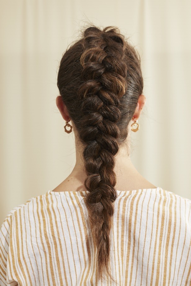 Femme aux longs cheveux bruns avec une tresse hollandaise
