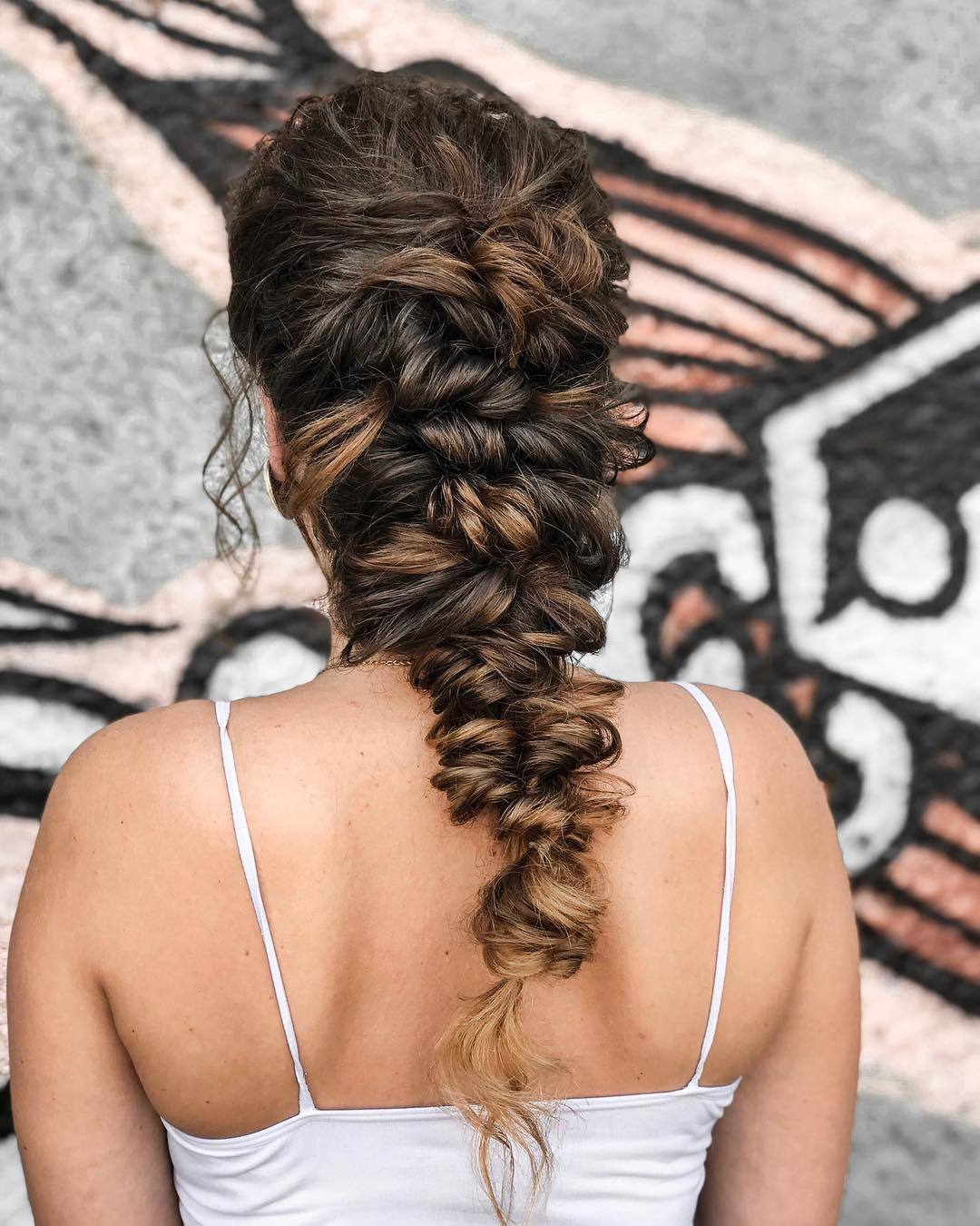 Femme brune avec une longue coiffure grecque en tresse