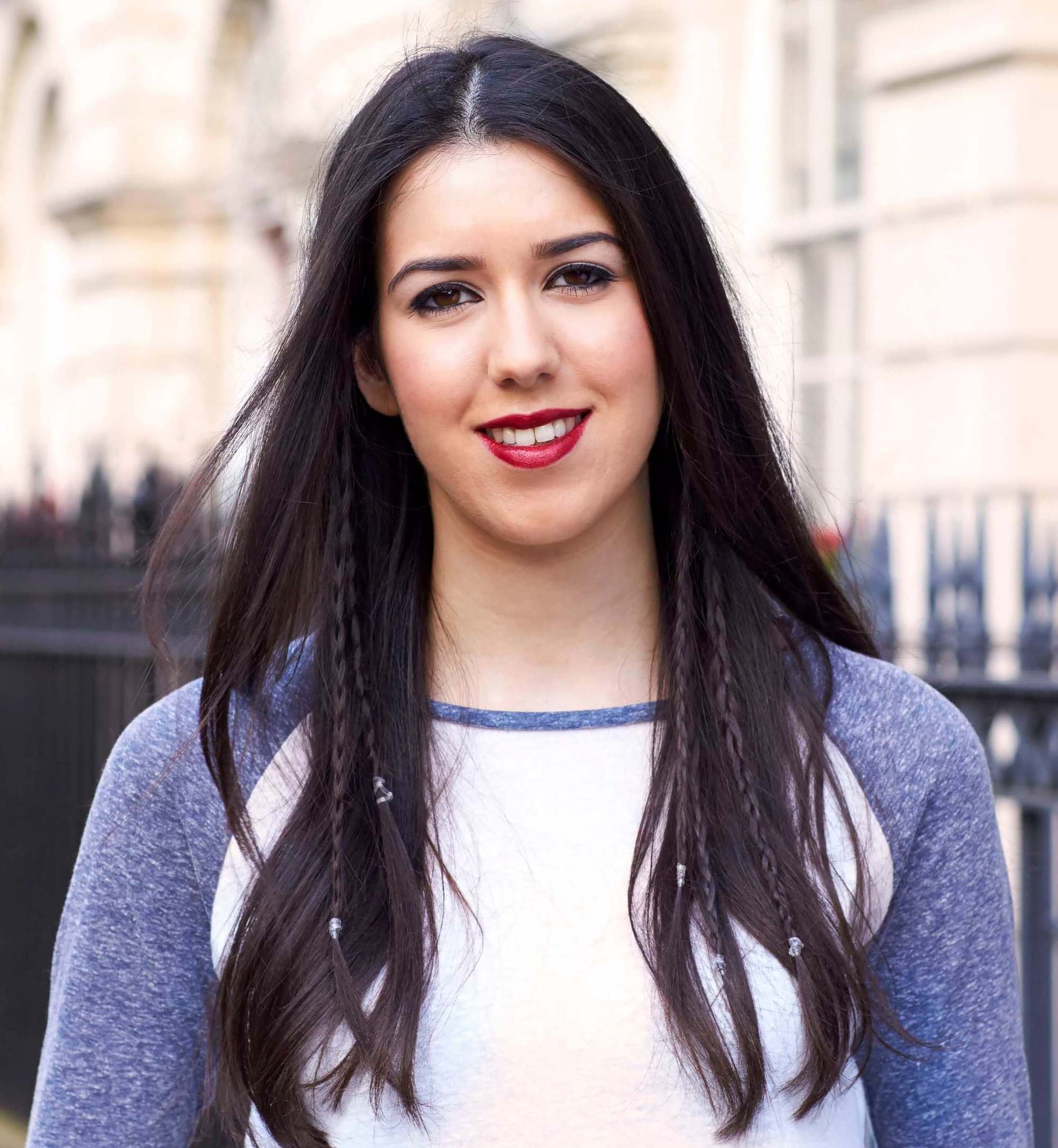 jeune femme brune avec des tresses cachées, portant un haut bleu et blanc