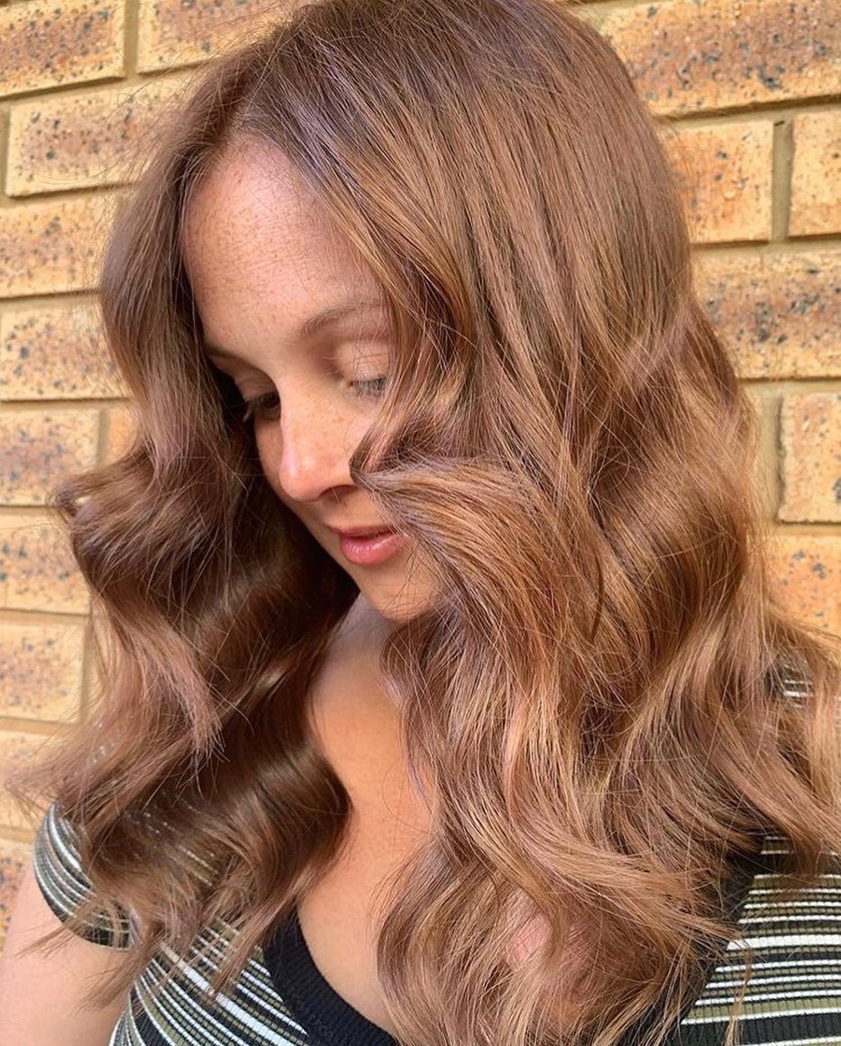 Femme aux cheveux caramel et châtain, coiffée en vagues