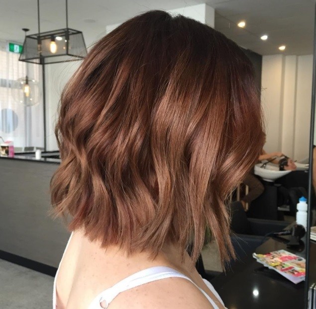 femme au bob court ondulé et aux cheveux châtains cuivrés au salon