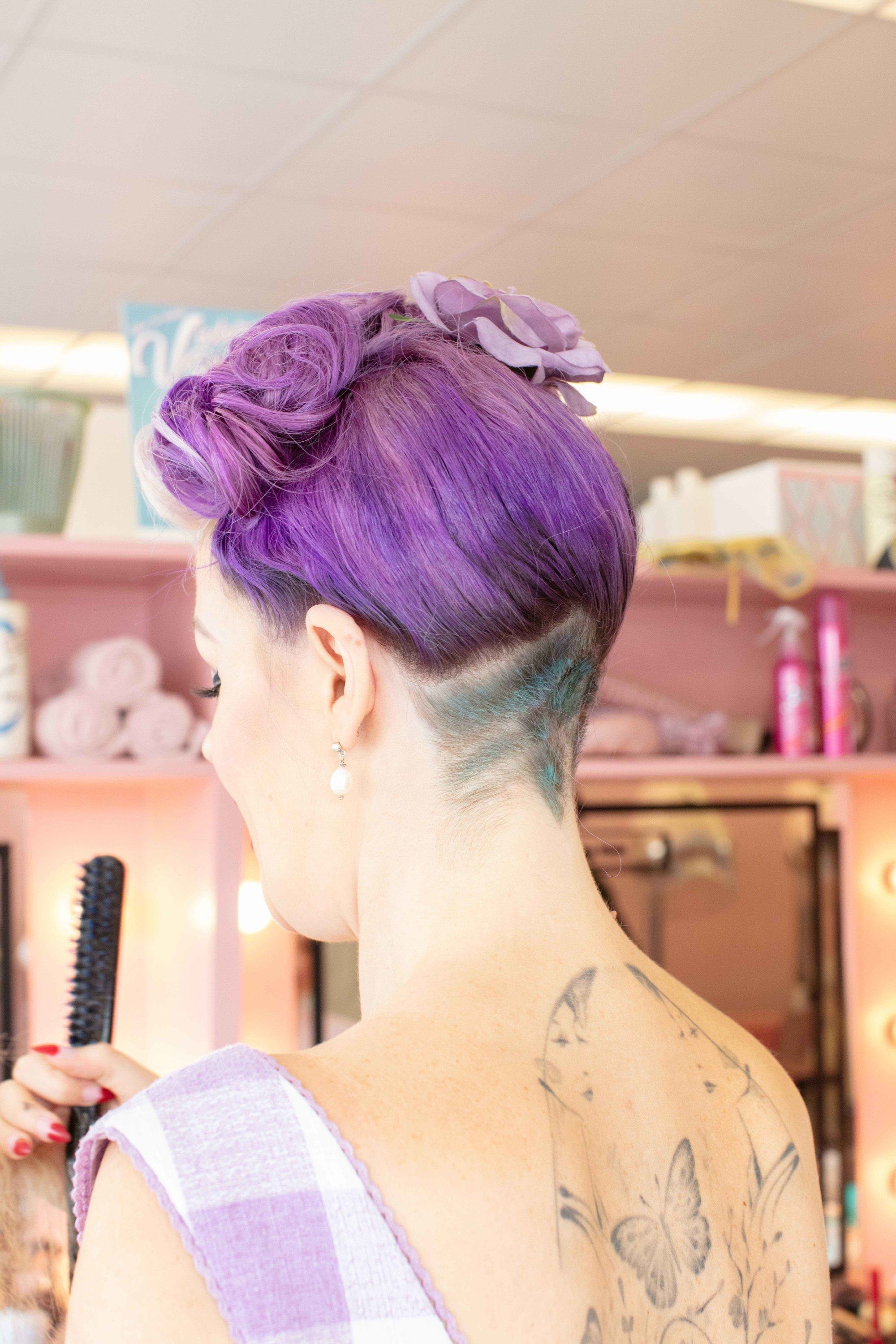 Coiffures vintage pour cheveux courts : Gros plan d'une femme aux cheveux violets courts, coiffée pour une victoire, enroulée avec une sous-coupe