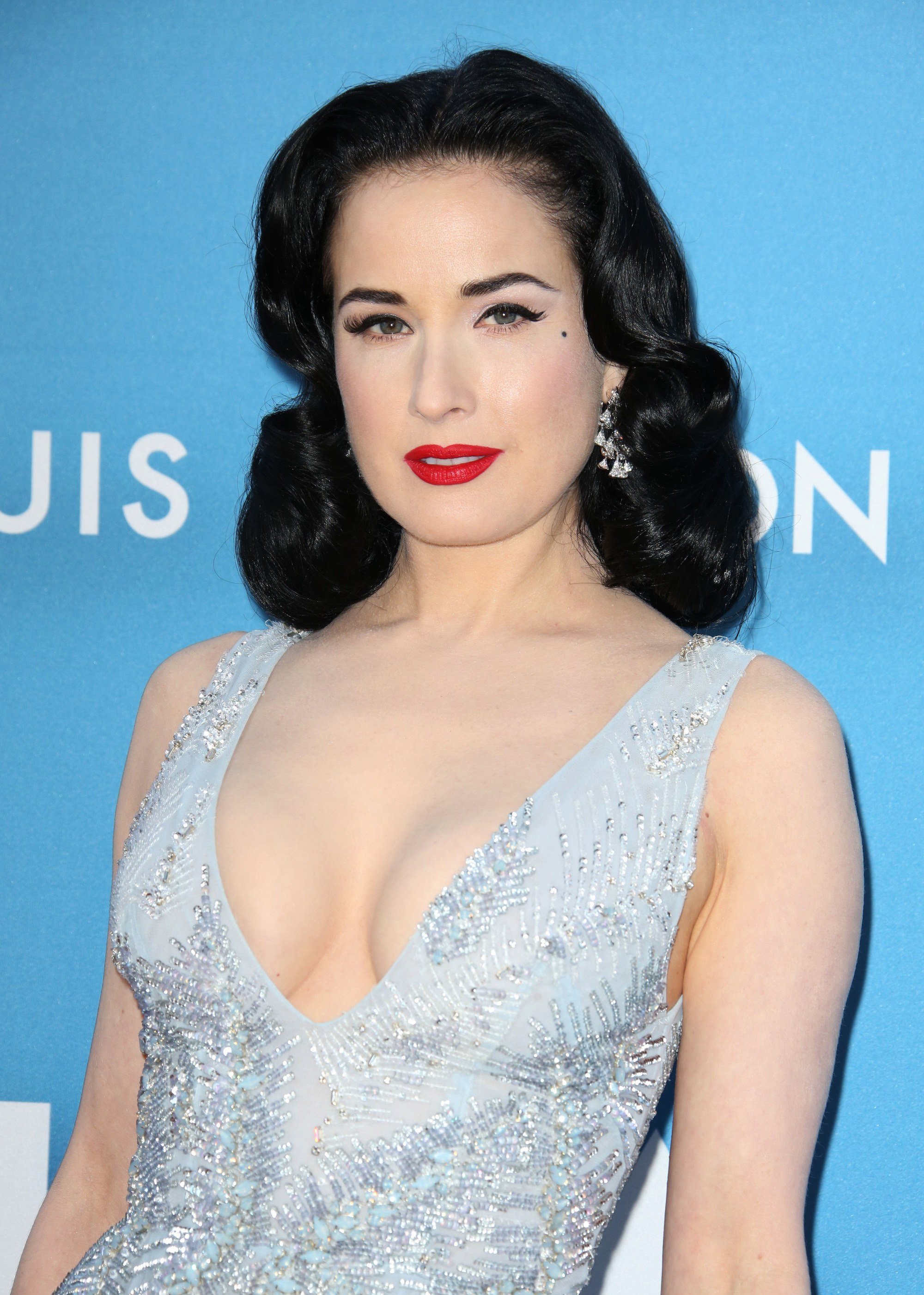 Cheveux courts vintage : Gros plan de Dita Von Teese avec un long bob brun foncé coiffé en vagues hollywoodiennes
