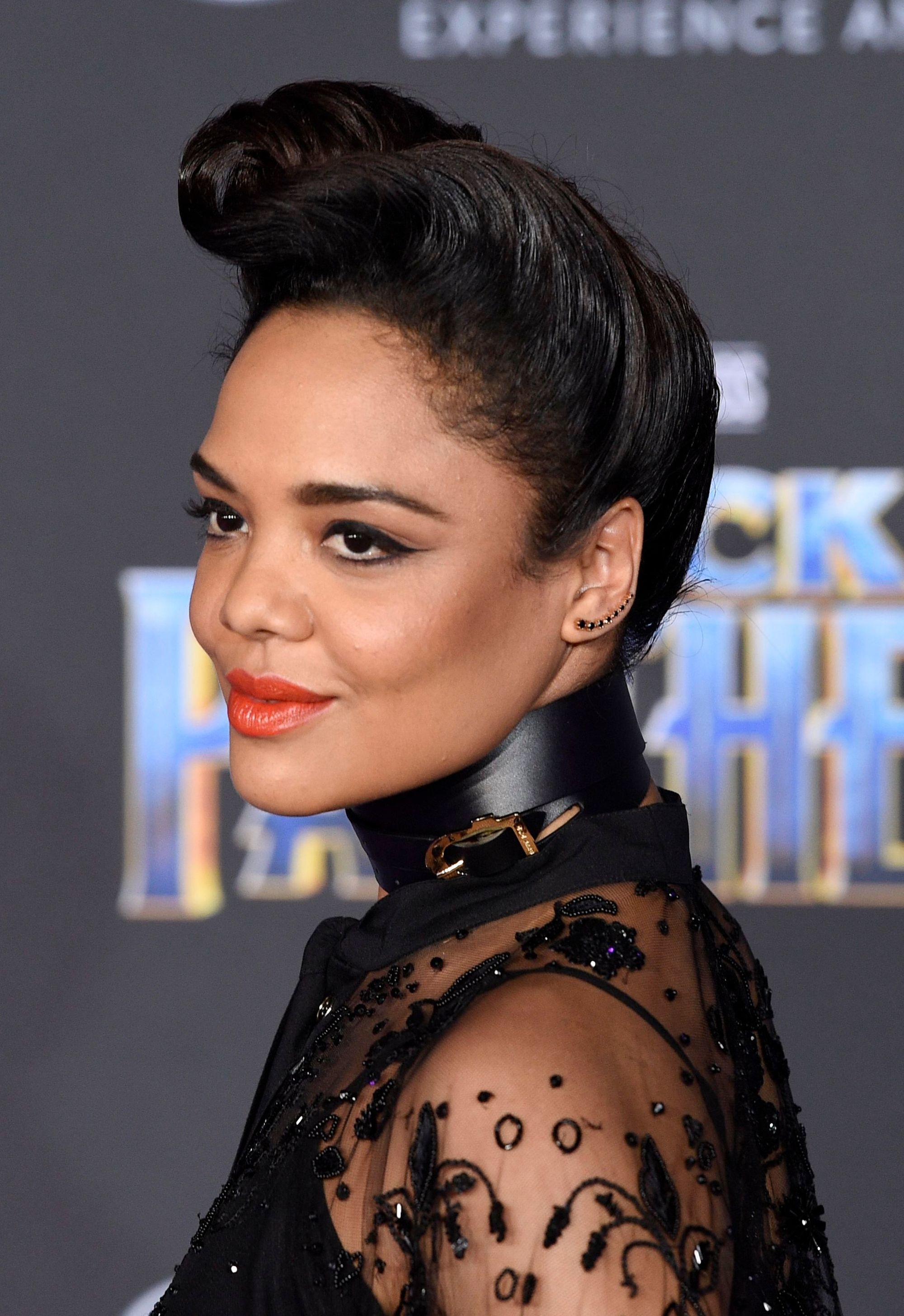 Cheveux courts vintage : Gros plan de Tessa Thompson avec des cheveux brun foncé défrisés, coiffés en une haute touffe roulée sur le tapis rouge