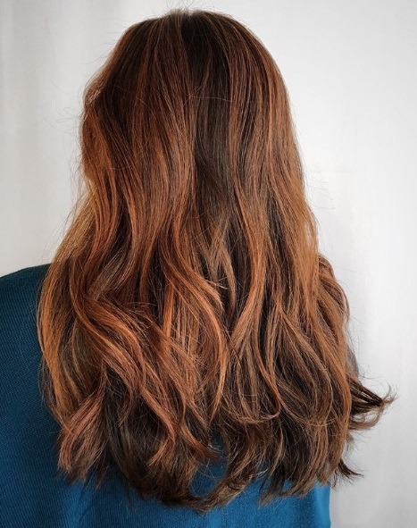 Femme aux cheveux mi-longueur auburn balayage