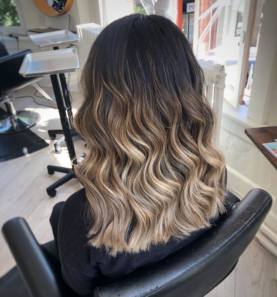 Femme aux cheveux mi-longs et ondulés d'un bébé blond
