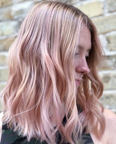 Femme aux épaules ondulées, cheveux rose clair en balayage