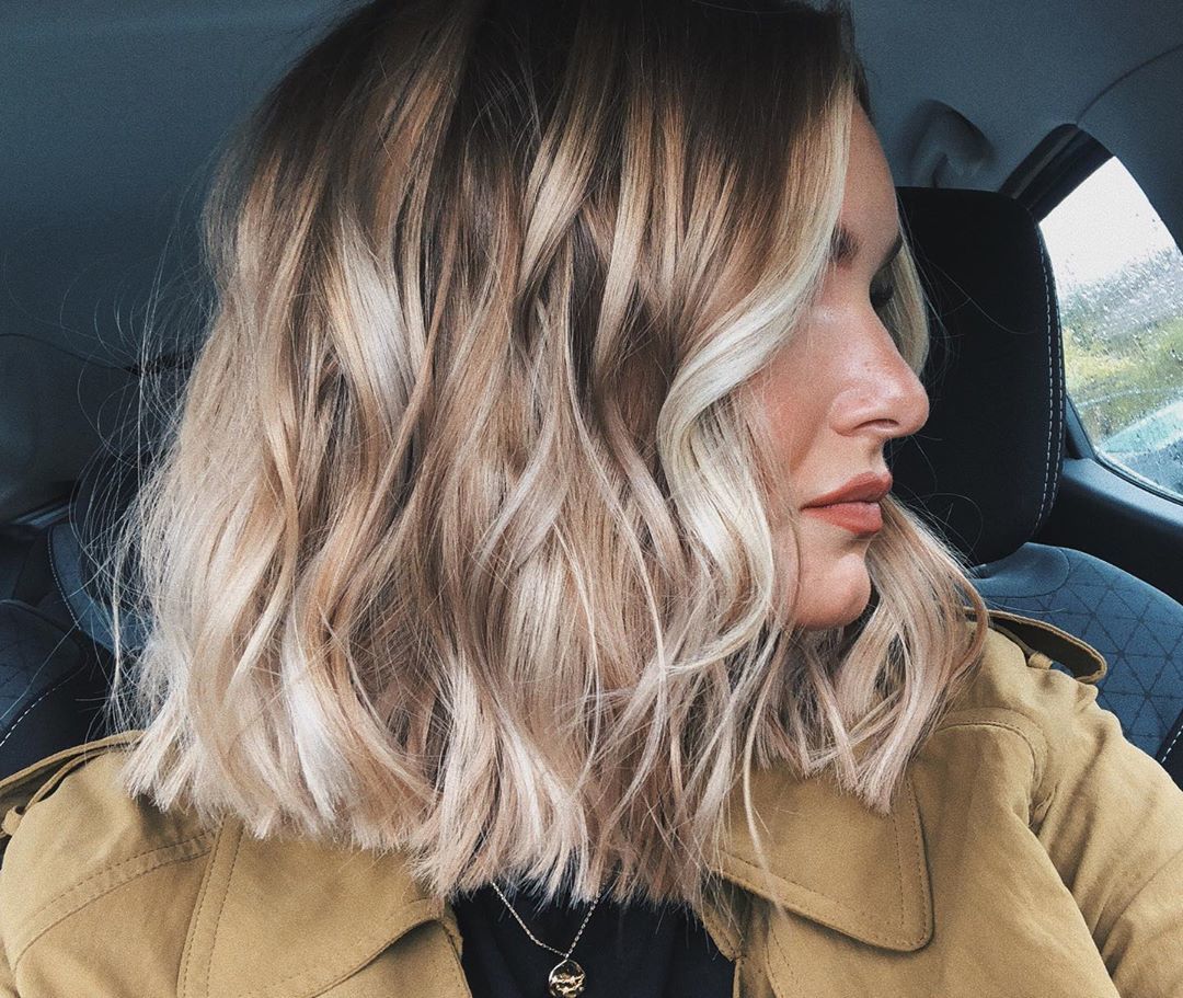 Femme avec un bob de balayage blond ondulé
