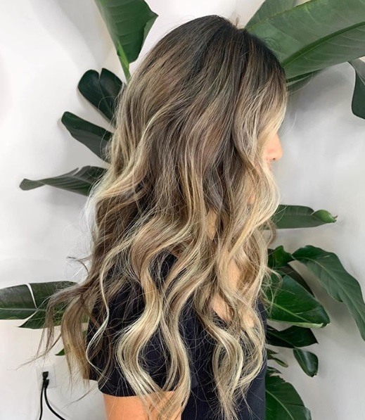 Femme avec un long balayage inversé blond bouclé