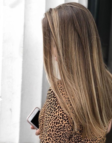 Femme aux longs cheveux bruns raides en balayage