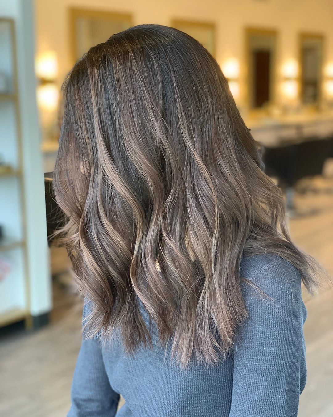 Femme avec des cheveux ondulés de longueur moyenne, brun clair, en balayage