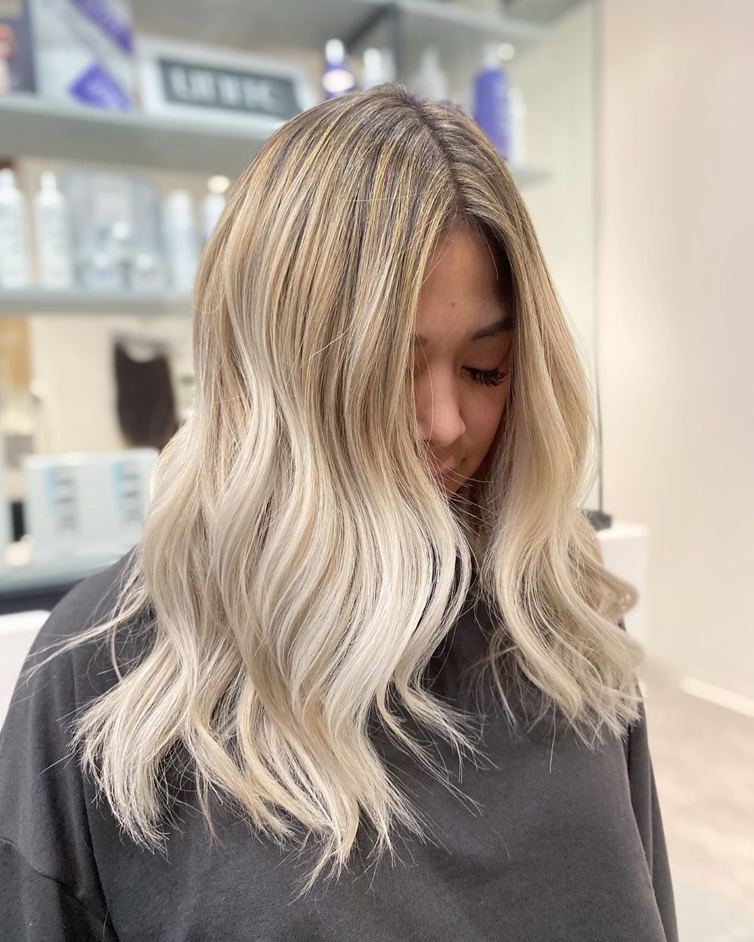 Femme aux cheveux blonds mi-longs ondulés de couleur beige