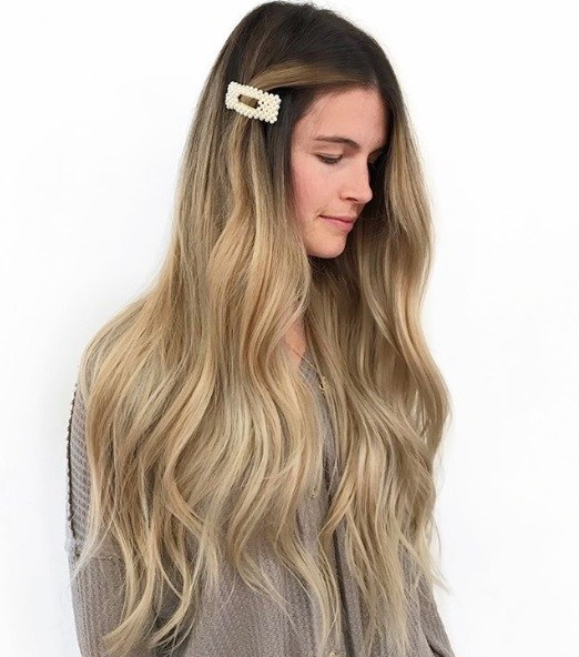 Femme avec de très longs cheveux blonds ondulés en balayage