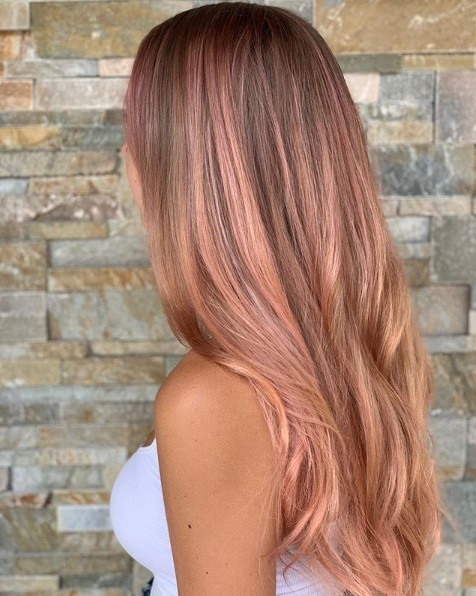 Femme aux longs cheveux en or rose de balayage