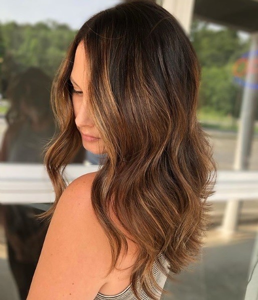 Femme aux cheveux mi-longs et ondulés de couleur caramel