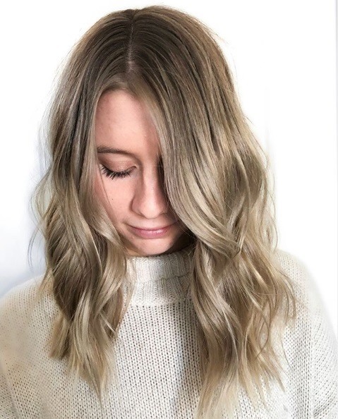 Femme avec des cheveux blonds ondulés à longueur d'épaules