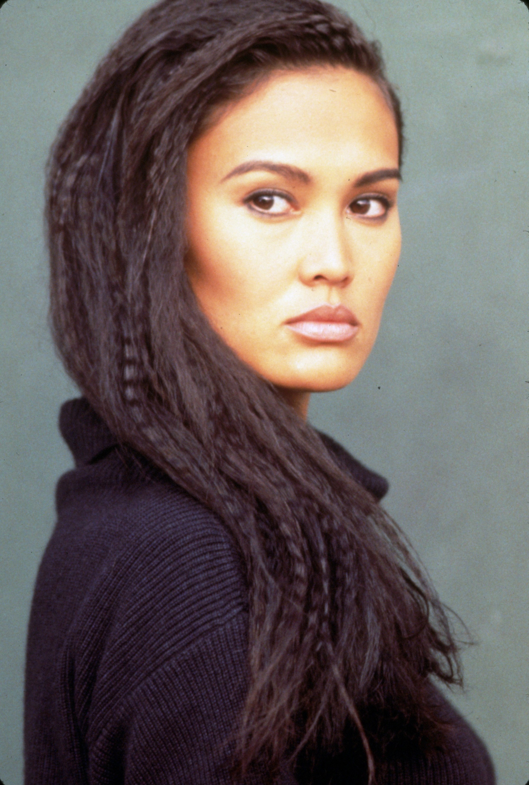 Tia Carrere avec de longs cheveux frisés dans les années 90