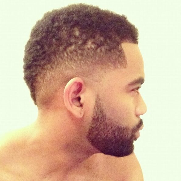 vue de côté d'un homme aux cheveux courts de style afro en faux mohawk avec une barbe