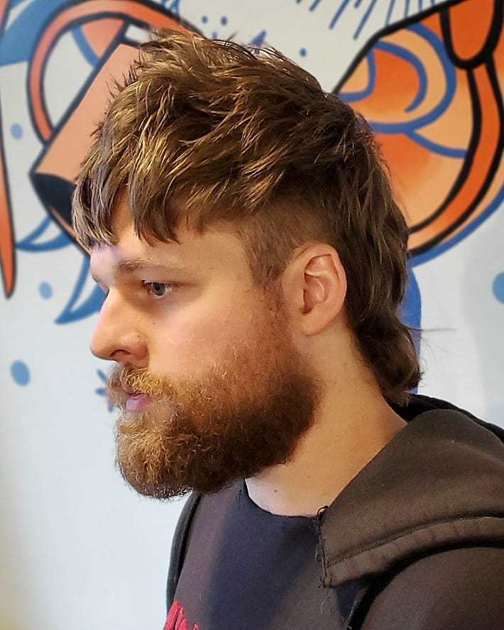 Homme aux cheveux bruns avec un mulet et une barbe