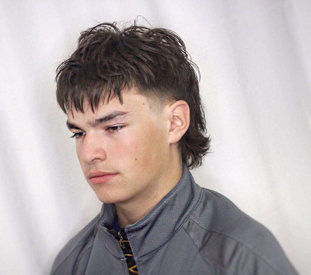 Homme aux cheveux bruns avec un mulet haché avec détail de rasage de temple
