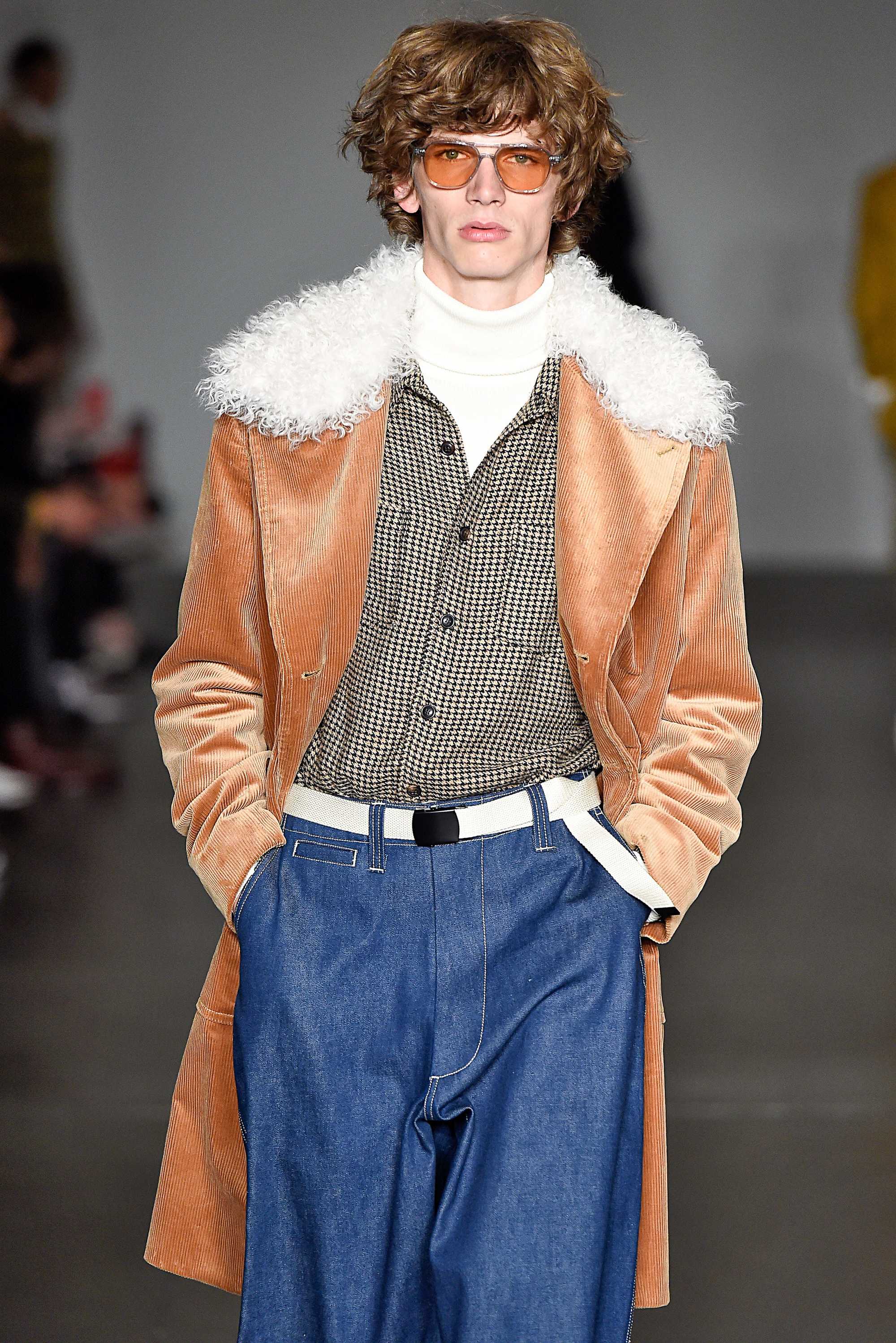 modèle masculin sur la piste de todd snyder fw18 avec des cheveux bouclés de longueur moyenne brun doré