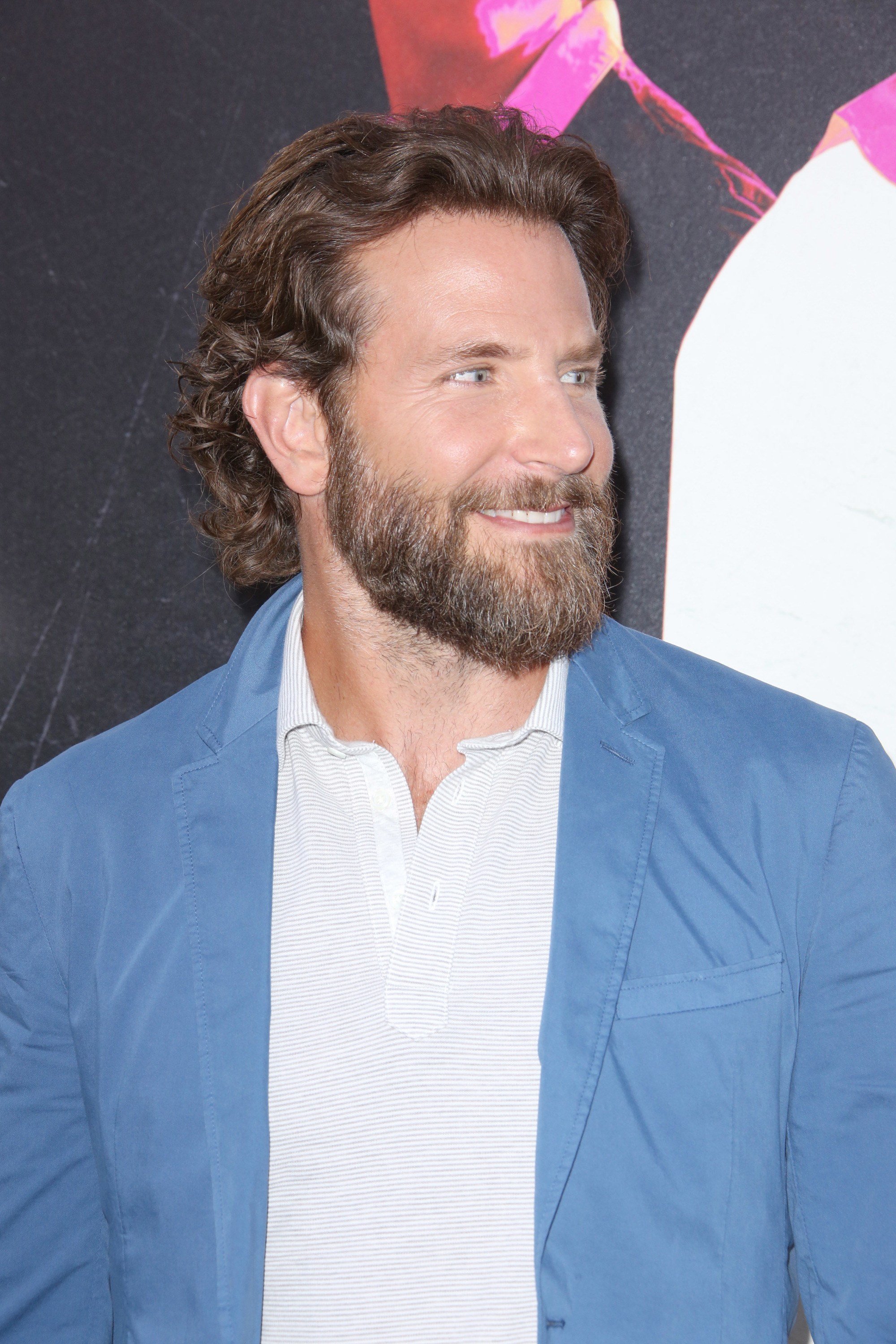 bradley cooper long cheveux bruns épais et ondulés, repliés derrière les oreilles et portant une longue barbe