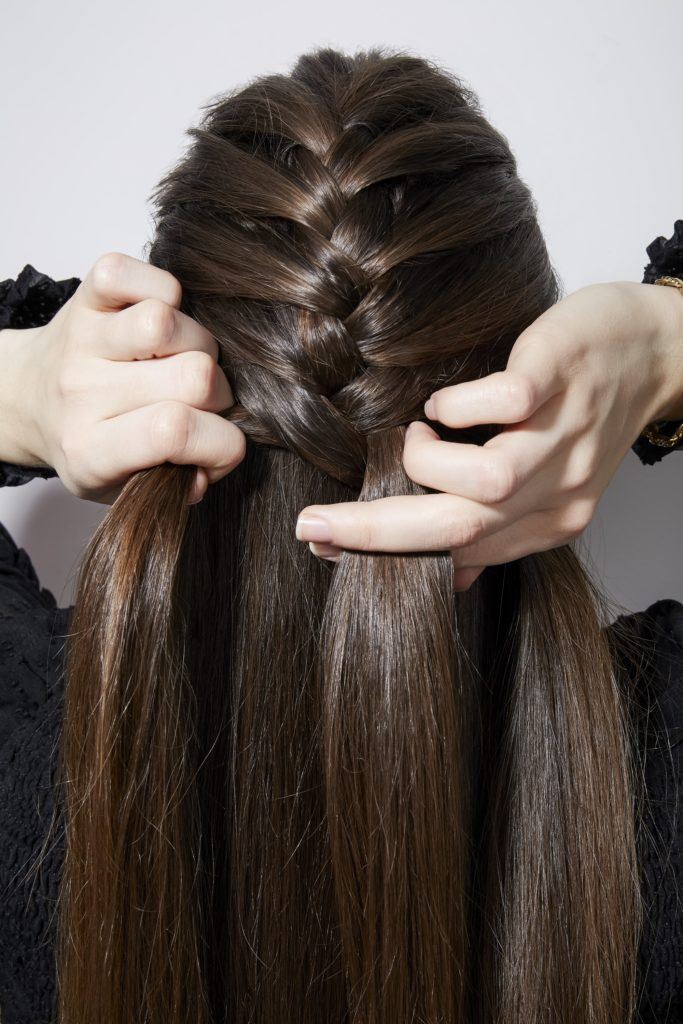 Comment tresser ses propres cheveux en français fille brune tressant l'arrière de la tête