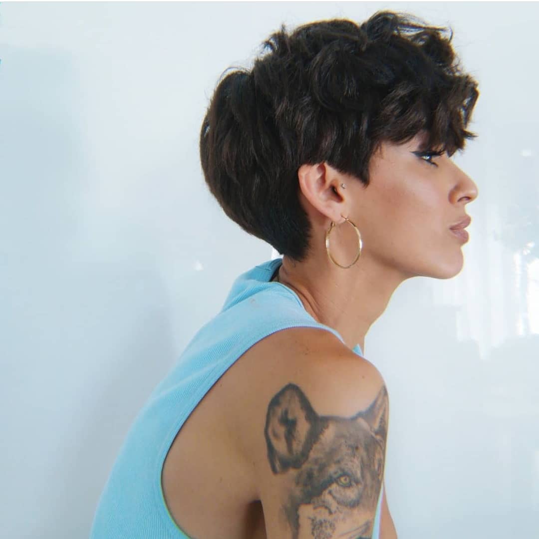 Femme avec des cheveux bruns foncés, épais et désordonnés.