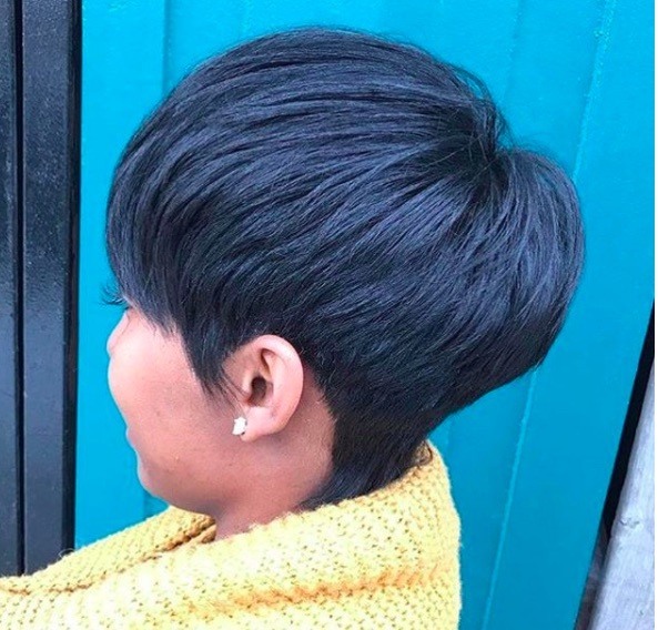 vue de côté d'une femme avec les cheveux en coupe champignon graduée et les cheveux noirs
