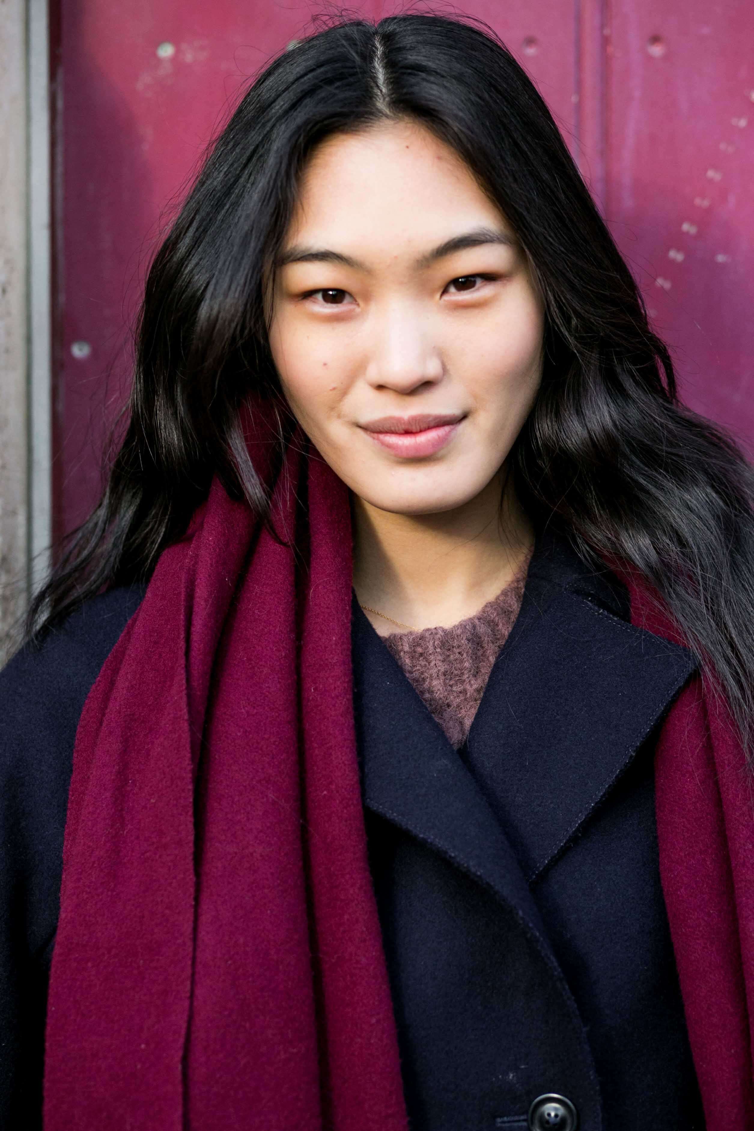 Coiffures asiatiques : Femme asiatique aux cheveux bruns foncés ondulés portant un manteau d'hiver et une écharpe.